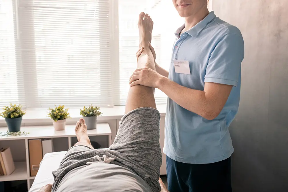 Do you need a referral for physical therapy in South Carolina? physiotherapist holding leg of patient while helpi 2021 09 24 03 23 55 utc top 7 instances a functional capacity evaluation can benefit you | excel rehab & sports